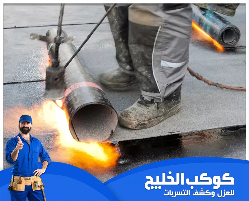 شركة عزل اسطح في الشارقة بالضمان | 0567121544 | كوكب الخليج رجل يرتدي بذلة زرقاء يحمل مشعل ناري يقوم بتثبيت مواد العزل، مستعداً للعمل علي عزل الاسطح بالشارقة.